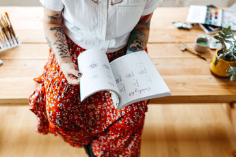 Lifestyle image of a woman holding a botanical line drawing book