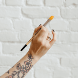 A hand holding a paintbrush