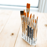 Paintbrushes and pens in a pen holder